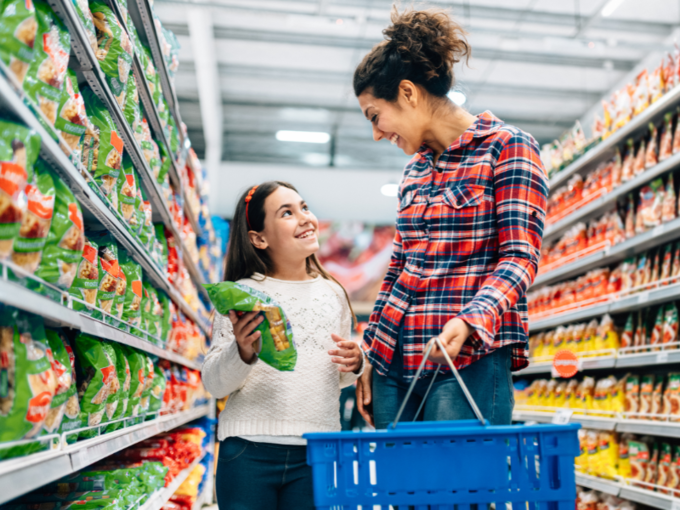 Eine Mutter und ihre Tochter lächeln sich im Supermarkt zu