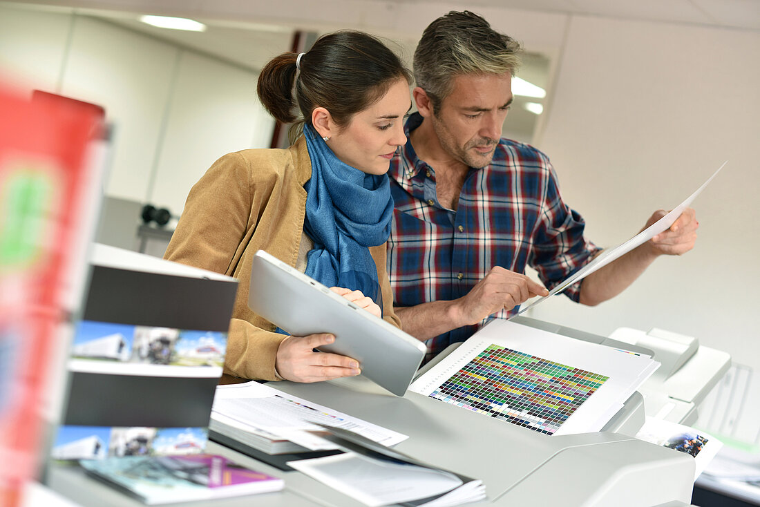Client in printshop controlling work before final printing