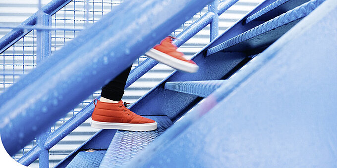 Symbolbild "Level-Up", ein Mensch geht eine Treppe hoch